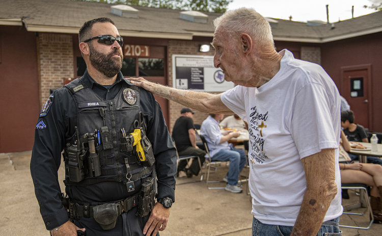 Georgetown police officer Keith Rhea takes time to visit with 88-year-old Orville Ramsey, right, during a National Night Out event held at Stonehaven Apartments.