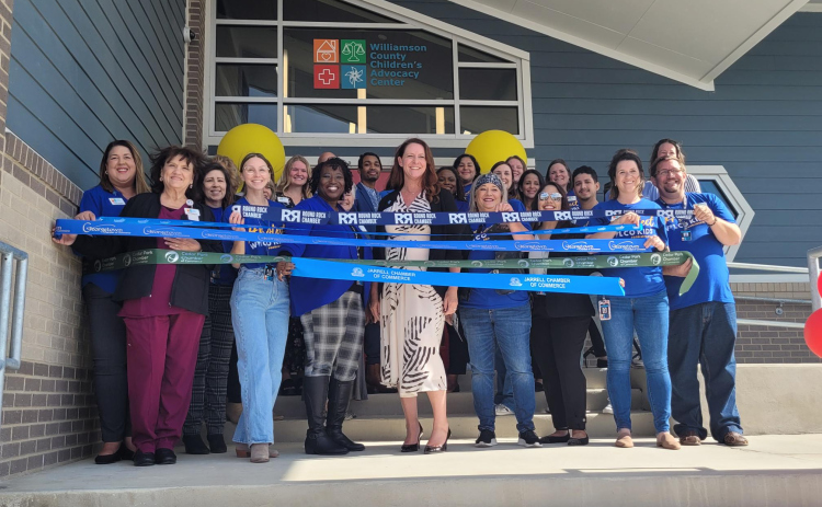 Williamson County Child Advocacy Center Chief Executive Officer Kerrie Stannell, center, stands with the center’s staff before they cut the ribbons at the grand opening on Friday November 3.