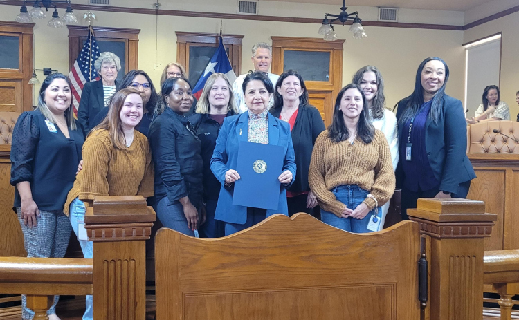 The Williamson County Commissioner's court and members from Tree of Angels pose for a photo after the commissioners voted to make December 5 Tree of Angels Day for the county. Photo by Nalani Nuylan.