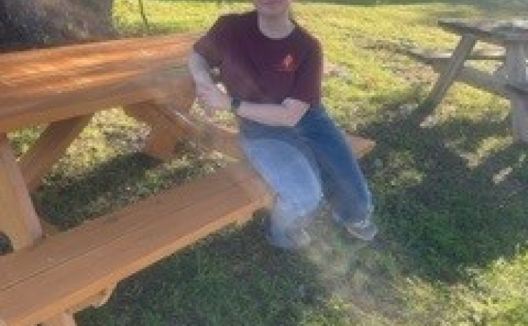 Maria Combes, 16, sits on a picnic table she constructed for her American Heritage Girl Stars and Stripes Award. Photo courtesy of Jennifer Morgan.