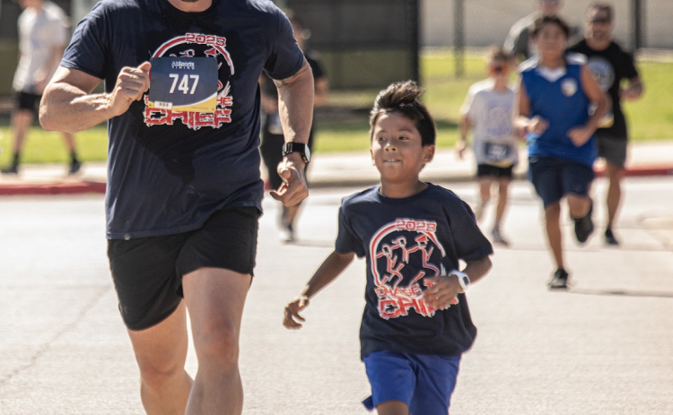 Georgetown Police Chief Cory Tchida, left, is joined by 8-year-old Ellison Shotwell as they near the finish line for their 5-K Race during Chase the Chief, held at East View High School on Sunday, March 5, 2023. Chief Tchida ran in both races.