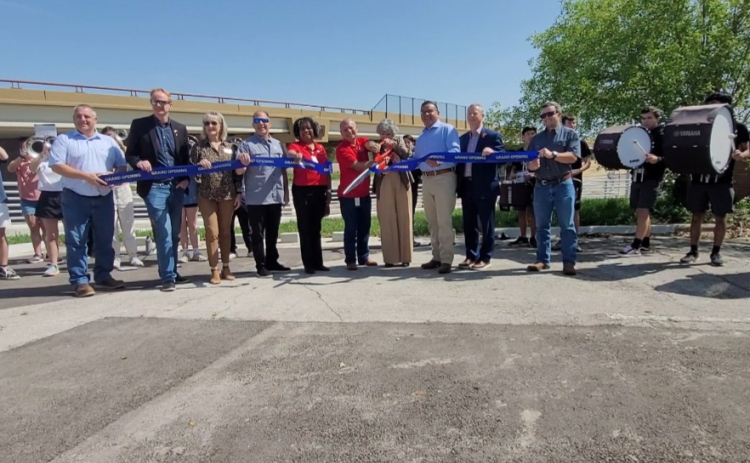 County Commissioner Terry Cook, right, and Round Rock City Council Member Frank Ortega, left, are joined by the Texas Department of Transportation and the Round Rock High School Band to cut the ribbon for the new Ranch to Market Road 620 / Chisholm Trail roundabout.  Photo by Nalani Nuylan.