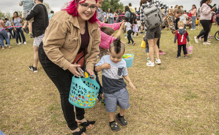 3-year-old Ismael Pulido is assisted by his mom Rebecca Pulido as he collects Easter eggs during the annual Easter egg hunt at Georgetown Church of the Nazarene on Saturday, March 30, 2024.