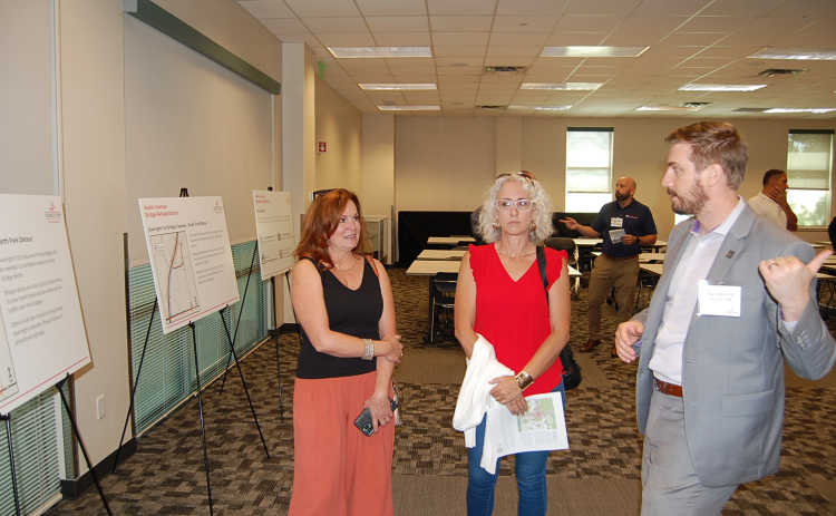 Engineer Paul Hahn, right, speaks to residents about the details of business access and lane closures during a Meet the Contractor event on June 27. (Photo by Kaitlyn Wilkes)