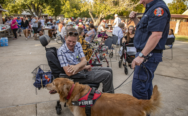 Shane Henry, left, visits with the Georgetown Fire Department’s Deputy Fire Marshal Jonathan Gilliam and Koda, the fire department’s fire dog during a National Night Out event October 1, at the Georgetown Housing Authority Activity Learning Center on West 18th Street. (Photo by Andy Sharp)