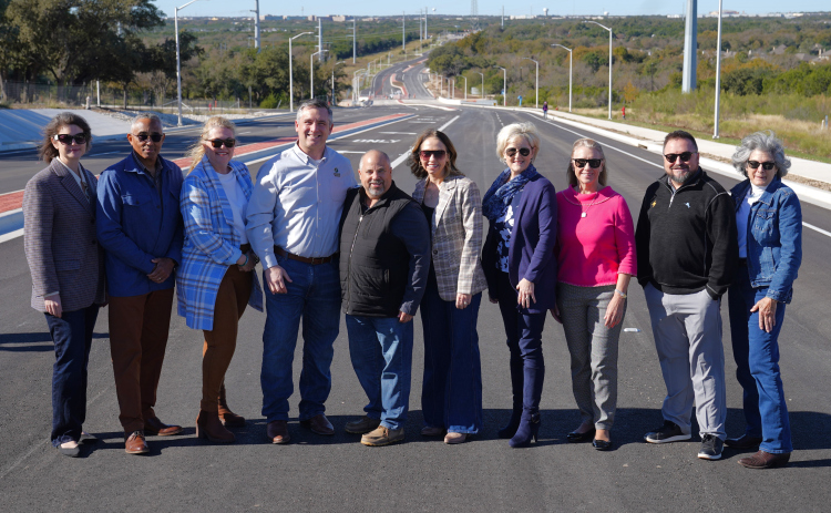 Wlico and Cedar Park officials celebrate New Hope Drive, a new road funded through city and county transportation bonds. Cedar Park Mayor Jim Penniman-Morin, center, stands on the road with Commissioners Valerie Covey, center right in blue, Cynthia Long, in pink, Terry Cook, far right, and others. Photos courtesy of the City of Cedar Park.