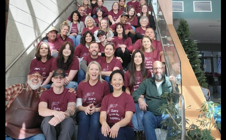 Kevin and Rachel Cummins, center, second row from the bottom, the owners of City Post and Sweet Lemon, with the volunteers who helped serve families for the event. (Courtesy Rooted Hospitality)