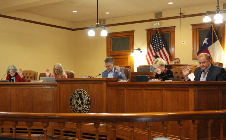 Williamson County Commissioners Court, from left: Terry Cook, Cynthia Long, County Judge Bill Gravell, Valerie Covey and Russ Boles, vote to hire a law firm to pause the operations of the Cameron County Housing Finance Corporation, February 25. Photo by Nalani Nuylan.