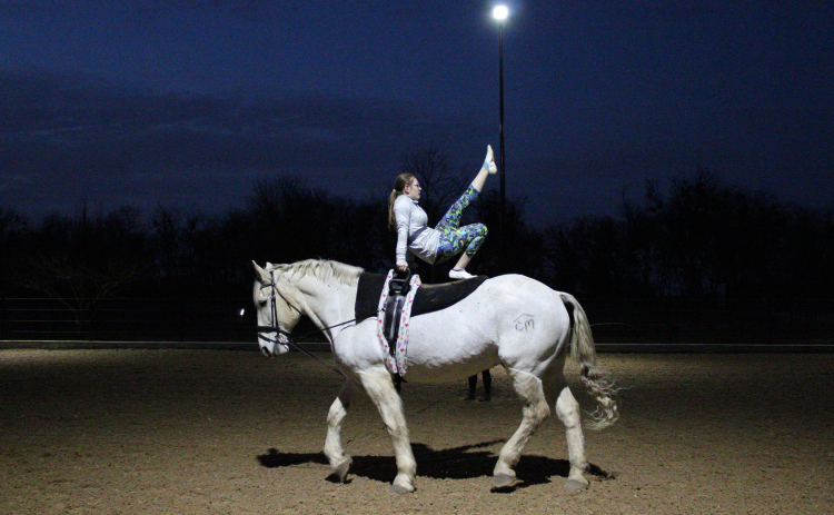 Grace Beach performs a candlestick pose on the trotter horse, Atlas in Weir during a Thursday night practice, on February 13.