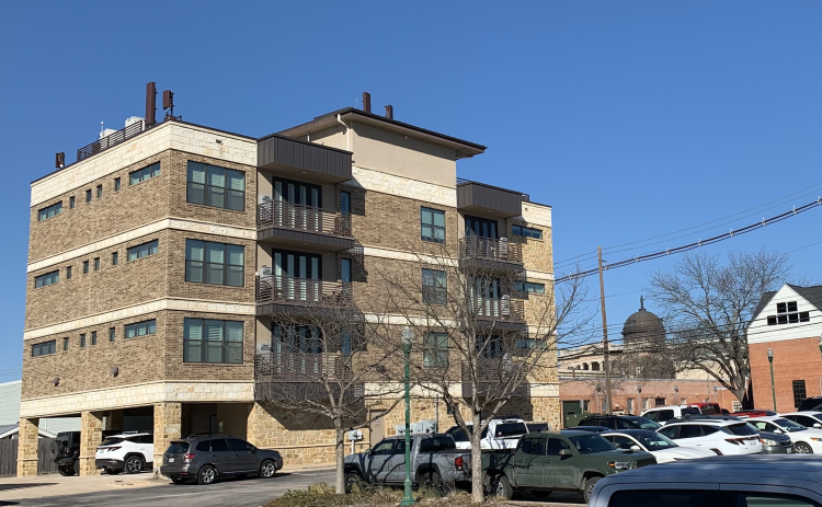 An apartment building located near the Georgetown Public Library is seen with the Williamson County courthouse in the background. If SB 840 passes, more multi-family buildings like this could appear downtown. (Photo by Kaitlyn Wilkes)