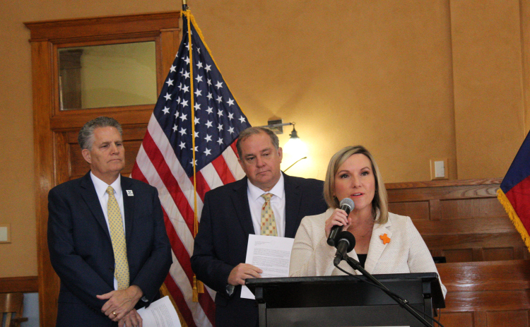 Hutto ISD Superintendent Jeni Neatherlin, right, explains how Hutto ISD will be impacted by the tax exceptions from Cameron County Housing Finance Corporation purchasing properties in Williamson County, March 5. She is accompanied by County Judge Bill Gravell, left, and County Commissioner Russ Boles, center. Photo by Nalani Nuylan.