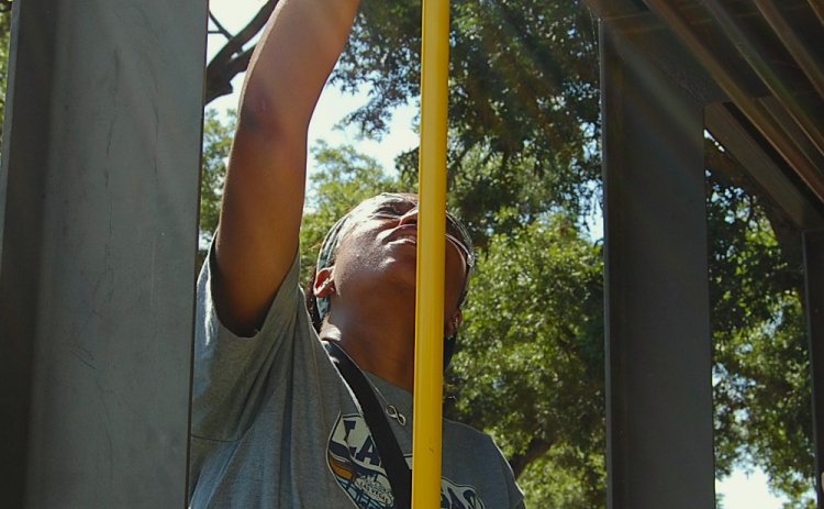 Pamela Okolie showed up to help at the Thursday, July 31 San Gabriel Park cleanup. She got rid of debris that was on top of pavilions due to the July 4 weekend flooding. (Photo by Kaitlyn Wilkes)