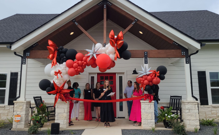 Isaiah 117 House Williamson County Location Leader Tara Thornton, center, gives a speech before cutting the ribbon to open the house, September 6. Photo by Nalani Nuylan.