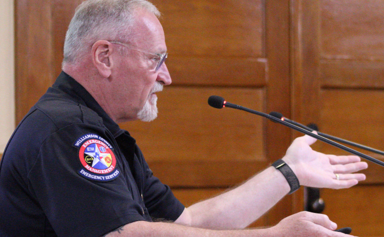 Emergency Management Director Bruce Clements provides an update on clean-up efforts during the Tuesday, October 14, commissioners court meeting. Photo by Nalani Nuylan.