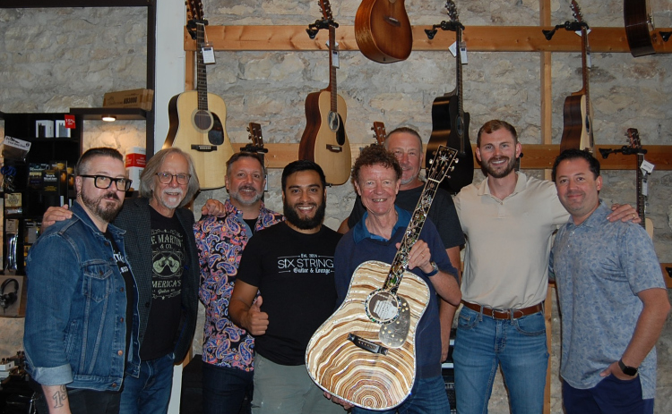 Left to right: Joey O, Craig Thatcher, Colin Besancon, Nick Cruz, C.F. Martin, Duncan Isenhower, Taylor Rountree and Ben Thompkins celebrate the arrival of Martin Guitars at Six Strings Guitar and Lounge on the Square. (photo by Kaitlyn Wilkes)