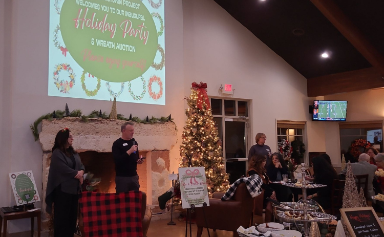 Rob Dyer, CEO of The Georgetown Project (center), is joined by Melissa Seigman, community engagement coordinator (left), at the nonprofit’s first Wreath Auction and Holiday Party, December 1. Photo by Nalani Nuylan.
