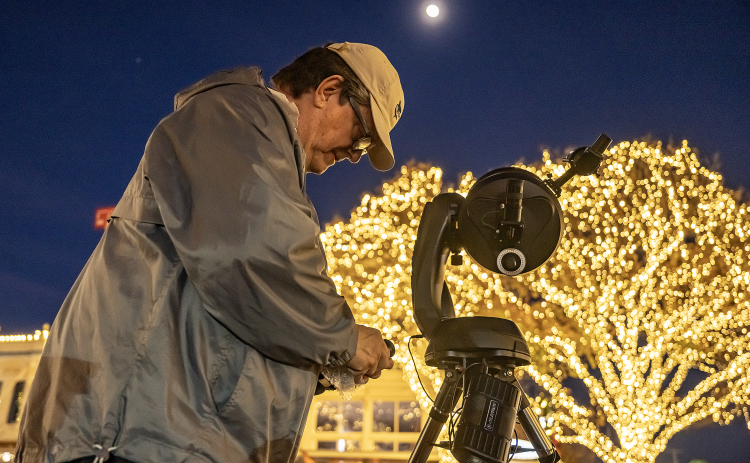 Brad Sloan sets up his telescope at 8th and Main Streets  for visitors to the Georgetown square to see an upclose view of the Waxing Gibbous moon, at 92.3% visibility on Wednesday, December 31, 2025, New Years Eve in Georgetown.   Photo by Andy Sharp.