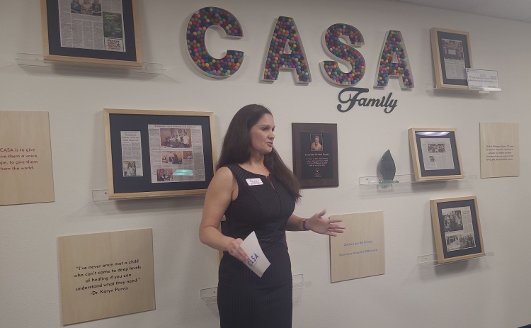 Marissa Austin, CEO of Court Appointed Special Advocates of Williamson County, gives a speech dedicating the room she’s in to Patti Hewlett, who is pictured on the wall, April 1. Photo by Nalani Nuyaln.