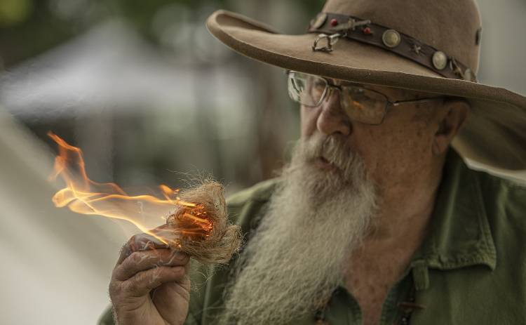 Mark Lynd makes fire using flint and steel during the 18th Annual Pioneer Days, held Saturday, May 4, 2024 at the Old Settlers Association site in Round Rock.  The event is hosted by the Williamson Museum.    Photo by Andy Sharp.