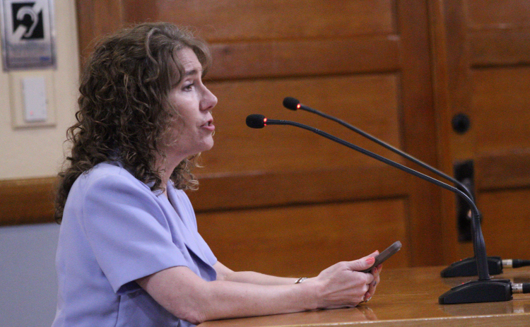 Stephanie Tibbets, vice president for the Saddle Creek Board of Directors for the HOA and a retired pediatric sexual assault nurse examiner, speaks against the proposed Justice Complex location during the May 12 Commissioners Court meeting. Photo by Nalani Nuylan.