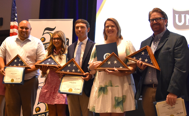 From left, Christie Parker-Wheeler, from the Rotary Club, Marie Alvarado, from Congressman John Carter’s office, and winners Bretton Schulz, Madison Runyan, Collin Buckley, Megan Mills, Seth Gipson and Chamber of Commerce President Shontel Mays at the 5 Under 40 Awards on May 8. The award winners are holding flags, courtesy of Mr. Carter’s office, that have been flown over the nation’s capitol building. (Photo by Kaitlyn Wilkes)