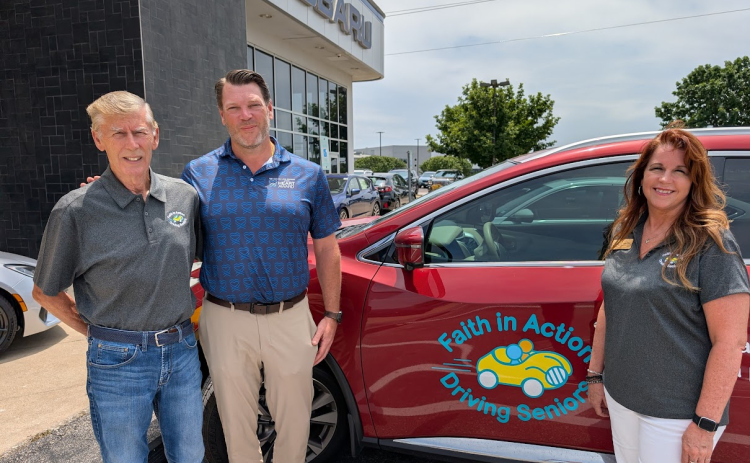Faith in Action Board Member Jim Wilson, Subaru of Georgetown GM Dan Azel,  and Faith in Action Executive Director Lisa Hoy stand with a vehicle.