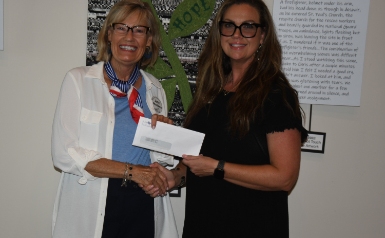 Judy Madsen, Women Helping Others vice president, meets with Sarah Bolton, executive director of Wilco Women’s Health Center, to make a donation.  Photo by Anne Marshall
