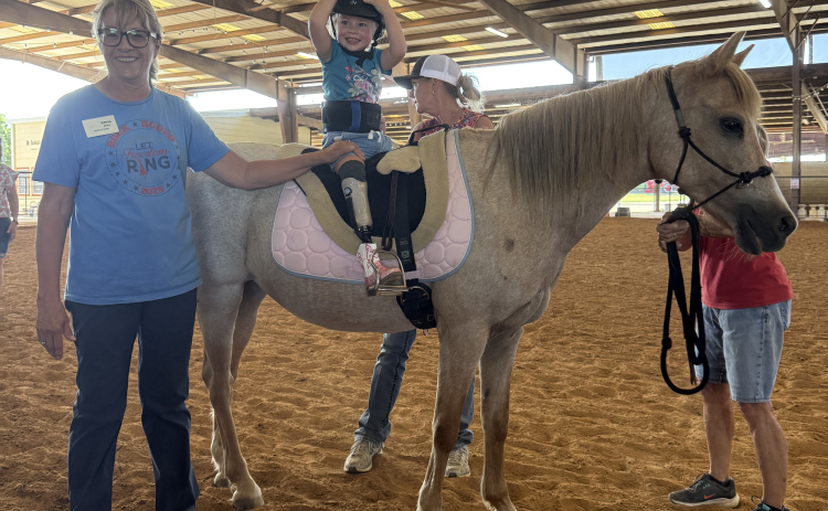 Charlee Penrod rides Sunny Girl during her lesson on July 22 with the help of ROCK volunteer Chris Miller.  Photo by Abbey Archer
