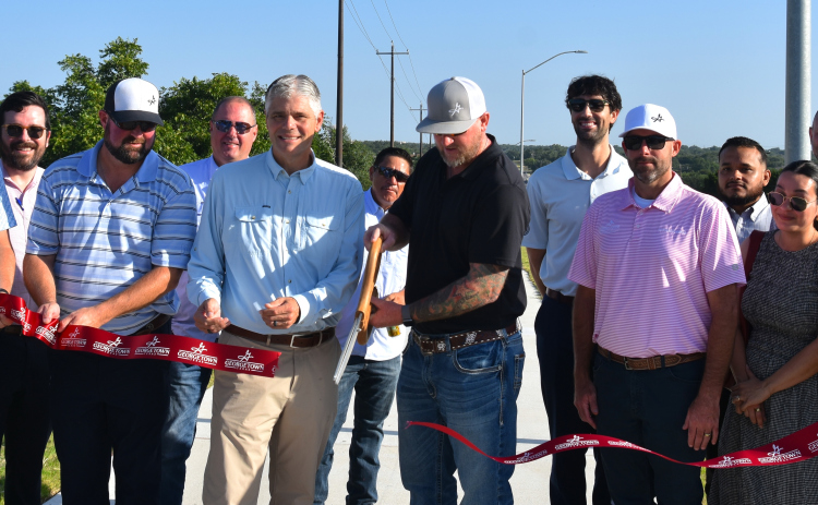 Members from the City of Georgetown, Kimley-Horn Engineers and Jordan Foster Construction gather on July 22 to cut the ribbon for the completion of phase 1 of DB Wood Road updates. (Photo by Kaitlyn Wilkes)