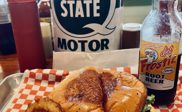 A photo, taken at a 45-degree angle, shows burger, cheese and bacon tucked into the bun. Photo by Linda Dwyer