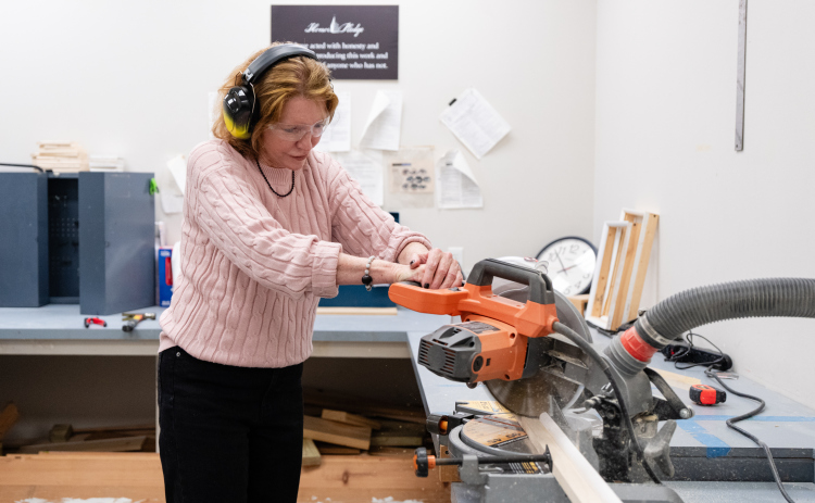 Southwestern University President Laura Skandera Trombley cuts wood to build a canvas as part of following senior Lainie Siegel’s schedule. (Courtesy Southwestern University)