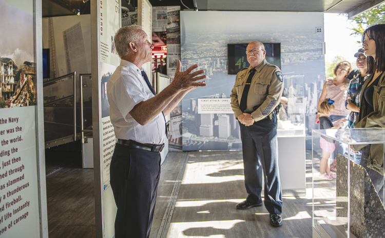 Steven Casquarilli, left, a retired New York City Fire Department firefighter, speaks to a group at the “Tunnel to Towers 9/11 Never Forget” exhibit at the Field of Honor Sunday, November 6. Included in the group was Williamson County Sheriff Mike Gleason, center.