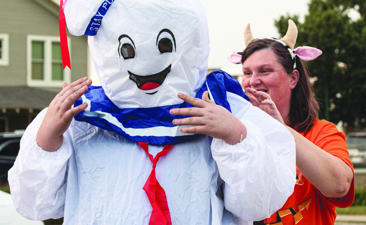 ANDY SHARP Easton Davis, 12, gets some help from his mom Doris Davis with his Ghostbusters Marshmallow Man costume as they get ready to enjoy Halloween night along Main Street in Old Town Monday, October 31. See more on Page 13